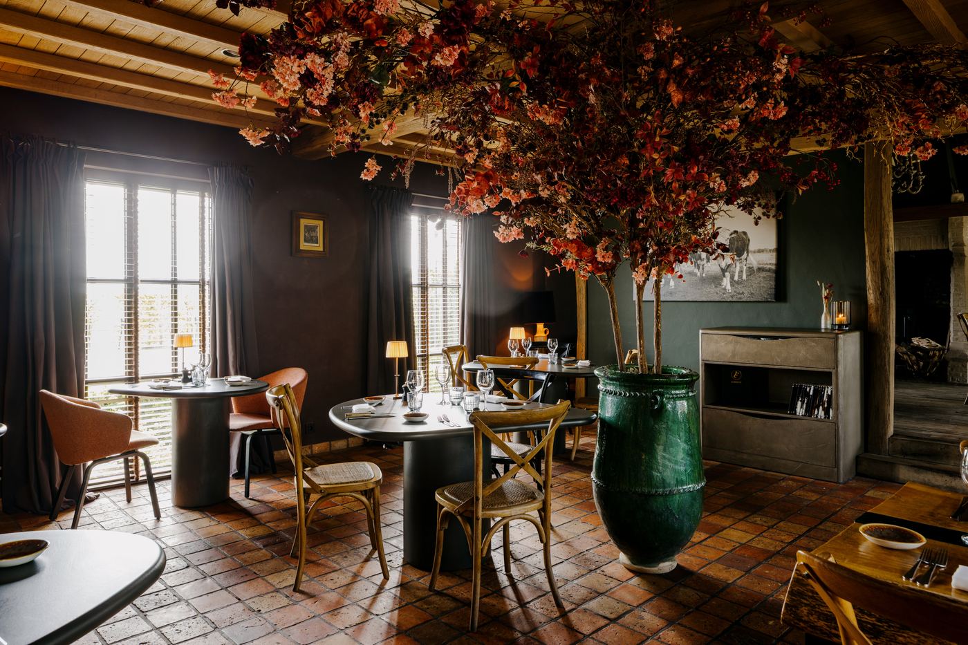 Sfeerbeeld van een restaurant in volle glorie — gedekte tafels onder een bloesemboom